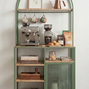 Könnte beinhalten: Eine grüne Kaffee-Ecke aus Metall und Holz mit einer Espressomaschine, einer Kaffeemühle und Zubehör. Enthält Kaffeetassen, Kaffeebohnen und einen Kupferkessel. Das Möbelstück hat mehrere Regale und einen Schrank. Maße in cm.