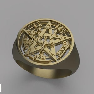 May include: Gold-coloured ring with a five-pointed star design inside a circular frame. The star has detailed symbols and text around the edge. The ring has a smooth, polished finish.