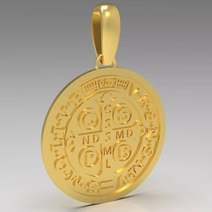 Könnte beinhalten: Ein goldfarbener Anhänger mit kreisförmigem Design. Der Anhänger zeigt geprägten Text und Symbole, darunter ein Kreuz und die Buchstaben "NDSMD" und "CSML". Der Anhänger hat oben eine Schlaufe für eine Kette.