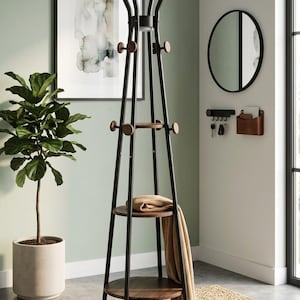 May include: A black metal coat rack with wooden accents and two shelves. The coat rack has multiple hooks and a top section with curved arms. A tan blanket and a folded sweater rest on the shelves. The rack is on a woven rug.