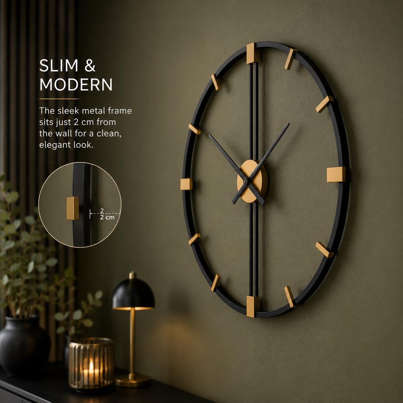May include: A round wall clock with a black metal frame and gold-colored accents. The clock features thin black hands and gold markers. Text on the image reads: SLIM & MODERN. The sleek metal frame sits just 2 cm from the wall for a clean, elegant look.