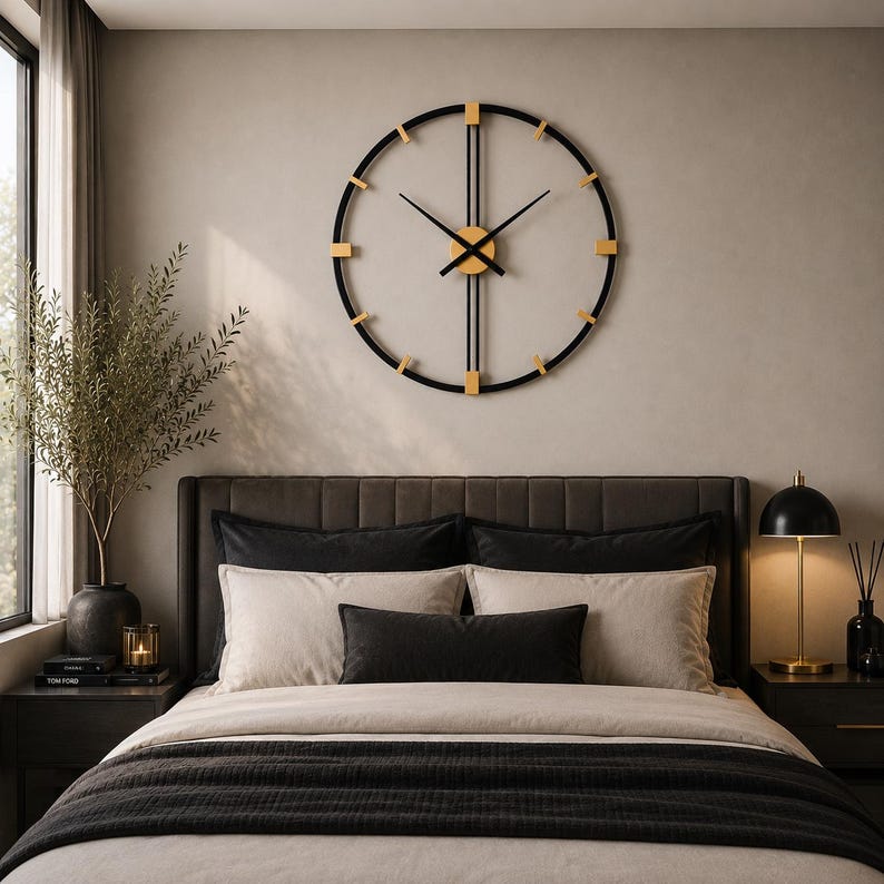 May include: A large circular wall clock featuring a thin black metal frame with gold-toned accents at the hour markers. The clock has two long black vertical bars intersecting at the center, with black hour and minute hands and a gold center.