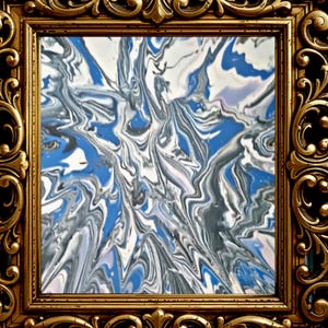 May include: Abstract art piece with a swirling pattern of blue, white, and gray colors. The artwork is framed in a gold-colored, ornate frame with detailed carvings, enhancing its decorative appeal. The overall aesthetic is modern and artistic.