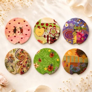 May include: Six circular coasters featuring various ladybug-themed illustrations. Designs include a pink background with hearts, a green apple and plaid pattern, a purple floral collage, swirling lines, a green field with stars, and a sunset landscape.