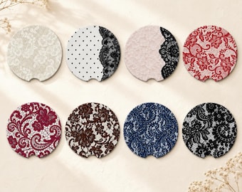 May include: Eight circular car coasters featuring various lace and polka dot patterns in colors including white, black, red, burgundy, brown, and navy blue. Each coaster has a small semi-circular notch along the bottom edge for easy removal.
