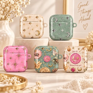 May include: Five square protective cases for wireless earbuds. One is cream with gold moons and stars, one is sage green with silver celestial motifs, one is bright pink with gold stars, one is teal with floral and sun designs, and one is cream with text.