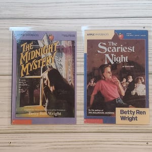 May include: Two paperback books with colorful covers. The book on the left is titled "The Midnight Mystery" and features a girl looking out a window. The book on the right is titled "The Scariest Night...of Erin's life!" and features a girl with a scared expression.