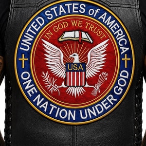 Può includere: Una toppa rotonda con le parole "UNITED STATES OF AMERICA" e "ONE NATION UNDER GOD". La toppa presenta un design rosso, bianco e blu con un'aquila, le parole "IN GOD WE TRUST" e le lettere "USA". La toppa è su un gilet di pelle nera.