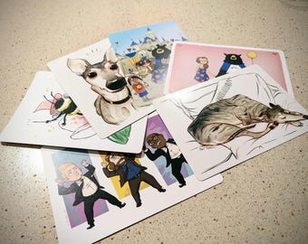 Könnte beinhalten: Ein Satz illustrierter Karten mit verschiedenen Motiven, darunter ein Hund, eine Biene, ein schlafender Windhund, eine Comicfigur und ein Schloss. Die Karten sind auf weißem Karton gedruckt und haben eine glänzende Oberfläche.