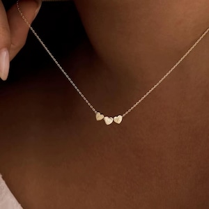 May include: A set of three ceramic mugs with a speckled, matte finish in cream, light grey, and dark grey. Each mug has a simple, minimalist design and a rounded handle.