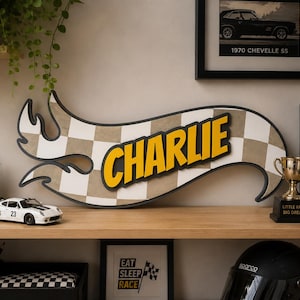 May include: A custom wall sign shaped like a racing track logo featuring a checkered pattern in beige and white. The name CHARLIE is displayed in bold yellow letters with a black outline, centred on the sign. The sign has a black border.