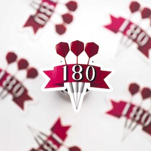 Op de afbeelding: Een sticker met drie darts met rode flights, een banner met het nummer "180" en extra stickers met vergelijkbare ontwerpen. De stickers hebben een witte achtergrond en een rood-wit kleurenschema.