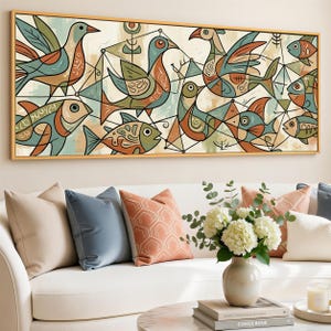 May include: Abstract art print featuring birds and fish in a geometric style. The artwork uses a palette of teal, orange, and brown against a cream background. The framed canvas is displayed above a white sofa with decorative pillows.