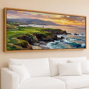 May include: Oil painting of a golf course on a cliff overlooking the ocean at sunset. The artwork features a golfer, green fairways, rocky cliffs, and crashing waves. The sky is a blend of orange, yellow, and purple hues, framed in a wooden frame.