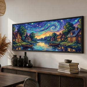 Peut inclure: Une impression d'art mural panoramique encadrée représentant un paysage nocturne vibrant avec un ciel étoilé tourbillonnant, une rivière calme reflétant la lumière, deux bateaux en bois et plusieurs petites maisons nichées parmi les arbres.