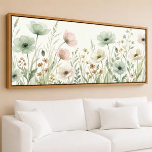 May include: Watercolor floral art print in a rectangular wooden frame. The artwork features a field of pastel-colored flowers, including pink, green, and white blooms, with green foliage and small yellow flowers. The background is a soft off-white.