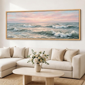 May include: A panoramic landscape painting of a turbulent ocean with white-capped waves under a soft pink and blue sunset sky, enclosed in a thin light wood frame. The artwork depicts a vast seascape with rolling water and a hazy horizon line.