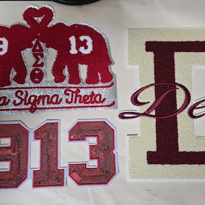 May include: Embroidered patches featuring red sequined numbers 1913, a red elephant design with the text "Delta Sigma Theta", and a maroon and cream letter "D" with the word "Delta".