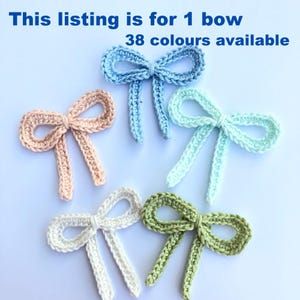May include: Five crocheted bows in different colours: light blue, pink, light green, white, and a darker shade of blue. This listing is for 1 bow. 38 colours available.