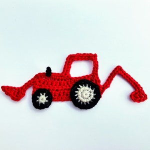 May include: A red crocheted tractor with black and white wheels and a black smokestack. The tractor has a front-end loader and a backhoe. The crochet work is detailed, and the tractor is set against a white background.
