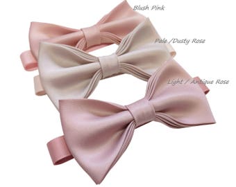May include: Three satin bow ties in different shades of pink. The bow ties are arranged from lightest to darkest, with the lightest being labeled "Pale/Dusty Rose", the middle being labeled "Blush Pink", and the darkest being labeled "Light/Antique Rose".