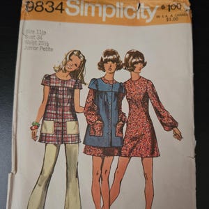May include: Vintage Simplicity Fashion Magazine pattern packet, size 11, featuring illustrations of three women in 1970s dresses and pantsuits. The packet includes the price of $1.00 and the number 9834.