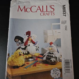 May include: A McCall's Crafts M6937 sewing pattern envelope featuring illustrations of three stuffed chicken and chick figures. The package displays the text McCall's Crafts, M6937, and OSZ, along with a barcode and various sewing notions.