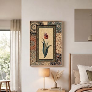 Puede incluir: Obra de arte enmarcada que representa un tulipán rojo y verde sobre un fondo beige. El marco está adornado con intrincados patrones en tonos azules, rojos y beige. El marco es de color marrón claro.