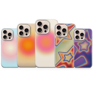 May include: Five phone cases with colourful, abstract designs. The cases feature a range of colours, including blue, yellow, pink, green, and purple. Each case has a different gradient or star pattern.