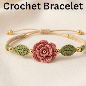 Può includere: Un braccialetto all'uncinetto con una rosa rosa e foglie verdi. Il braccialetto ha un cordoncino beige con perline color oro. Il testo "Crochet Bracelet" è nella parte superiore dell'immagine.
