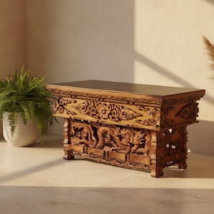 May include: A rectangular wooden table featuring intricate hand-carved dragon motifs along the base and detailed floral patterns on the upper apron. The piece has a smooth, flat top surface and is constructed from a medium-toned natural wood grain.