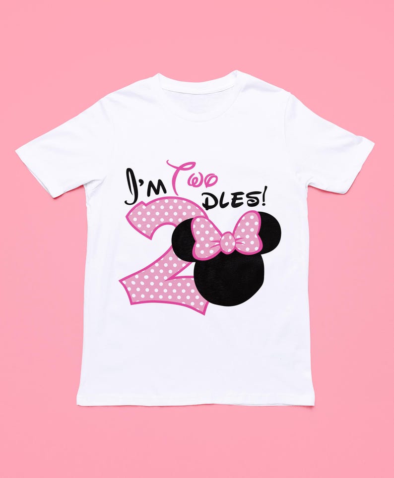 May include: White t-shirt with a pink polka dot number "2" and a pink bow on a black Mickey Mouse head. The text "I'm Two DLES!" is printed on the shirt.