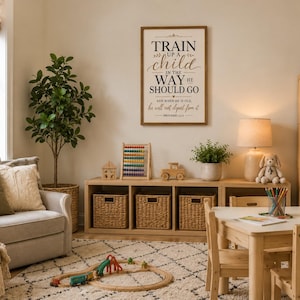 Könnte beinhalten: Ein rechteckiges Wandbild aus Holz mit schwarzem Text, der lautet: TRAIN UP A CHILD IN THE WAY HE SHOULD GO AND WHEN HE IS OLD, he will not depart from it. PROVERBS 22:6. Das Schild hat einen hellen Hintergrund und einen dunklen Holzrahmen.