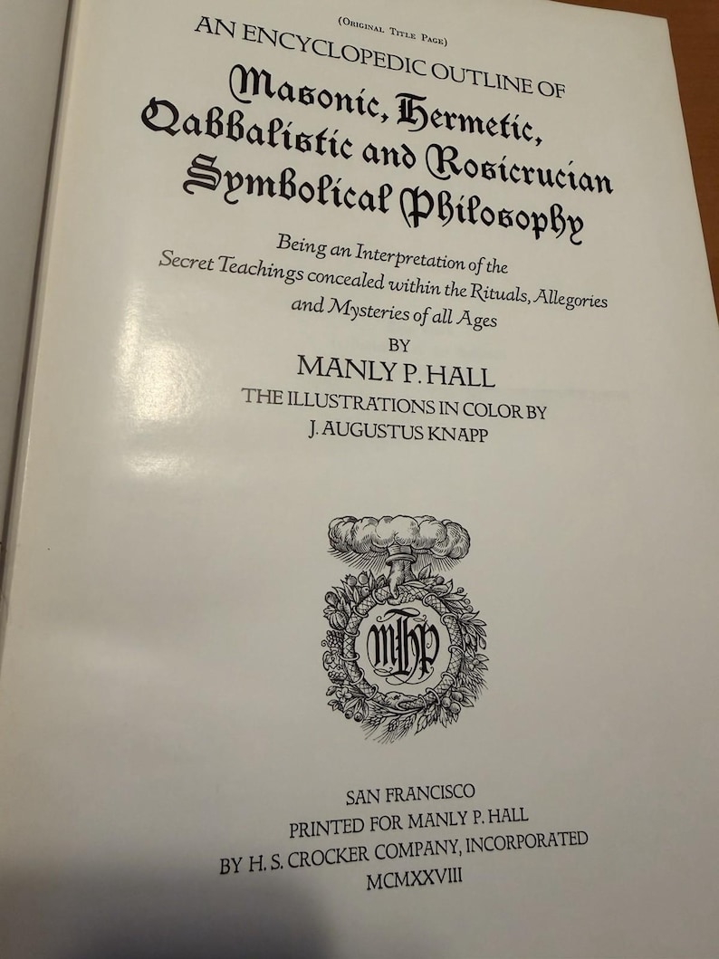 Puede incluir: La p&aacute;gina de t&iacute;tulo del libro An Encyclopedic Outline of Masonic, Hermetic, Qabbalistic and Rosicrucian Symbolical Philosophy de Manly P. Hall. Presenta texto negro sobre una p&aacute;gina blanca, incluyendo un emblema circular con las iniciales MPH.