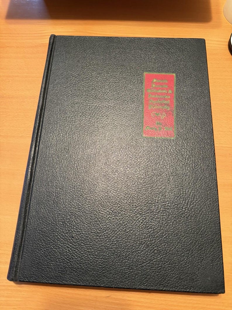 Puede incluir: Un libro de tapa dura negro con un acabado texturizado similar al cuero. En la portada, hay una etiqueta rectangular roja con texto dorado que dice: "Reports, Statistics & Journals of the Legislature of the State of Maine, Vol. II, June 1851".
