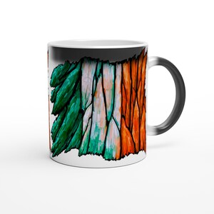Könnte beinhalten: Weiße Keramiktasse mit schwarzem Henkel, mit einem farbenfrohen abstrakten Design in Grün, Weiß und Orange, das der irischen Flagge ähnelt. Das Design bedeckt einen Teil der Tassenoberfläche.