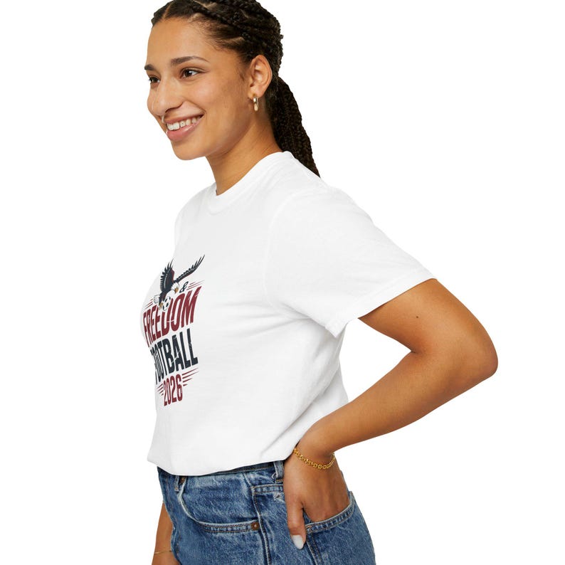 Woman wearing a white t-shirt with "FREEDOM FOOTBALL 2023" graphic.
