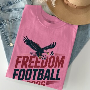 Cream t-shirt with eagle, football, and "Freedom Football 2026" text.