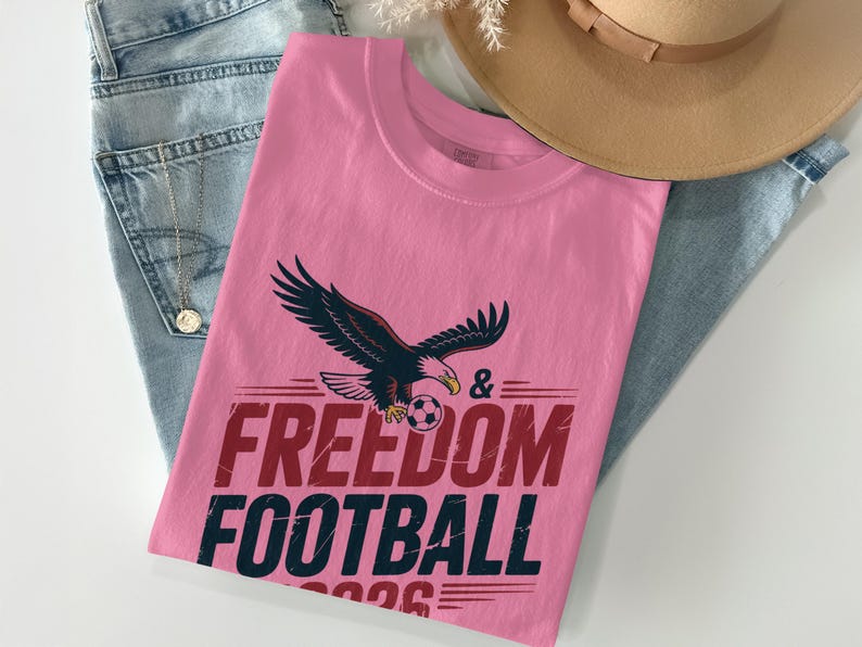 Cream t-shirt with eagle, football, and "Freedom Football 2026" text.