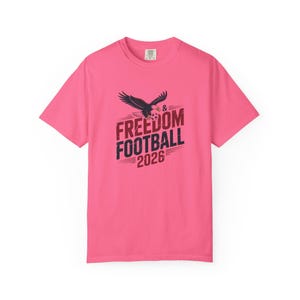 Pink t-shirt with eagle and "Freedom Football 2026" text.