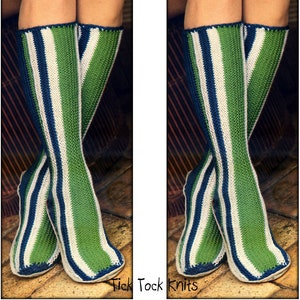 May include: A pair of green, white, and blue striped socks with a tick-tock knit pattern. The socks are folded down at the top and the toes are visible.