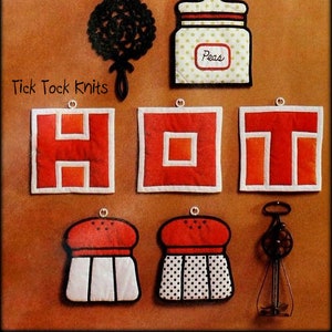 Puede incluir: Conjunto de cuatro posavasos de tela roja y blanca con la palabra "HOT" escrita. Los posavasos están rodeados por un juego de salero y pimentero blanco y negro, un batidor negro y un tarro blanco y verde con la palabra "Peas" en él.