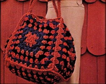 Può includere: Una borsa a mano in crochet rosso e nero con un motivo quadrato. La borsa è tenuta da una persona che indossa una camicia arancione bruciato e pantaloni beige. Il testo "Tick Tock Knits" è visibile nell'immagine.