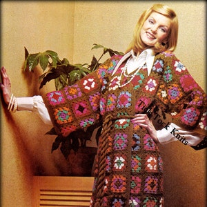 May include: A brown crochet cardigan with a colorful granny square pattern. The cardigan has a belt and long sleeves. The model is wearing white pants and a white collared shirt with a pearl necklace.