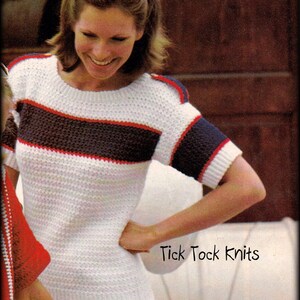 Puede incluir: Top de punto blanco con rayas y detalles en azul marino y rojo. La parte superior de manga corta tiene cuello redondo y se combina con una falda blanca. El texto "Tick Tock Knits" es visible.