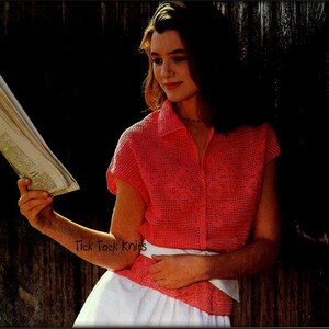 May include: A woman wearing a pink crocheted top with a white skirt and a white belt. She is holding a newspaper in her left hand. The text "Tick Tock Knits" is visible in the image.