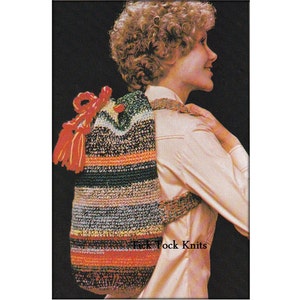 May include: A crocheted backpack with a striped pattern in shades of blue, green, orange, and red. The backpack has red tassels and a red bow.