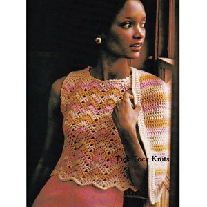 May include: A crochet top with a chevron pattern in shades of pink, orange, and cream. The top has a scalloped hem and is sleeveless. The model is wearing a matching crochet shawl.
