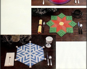 Peut inclure: Trois sets de table en tricot avec des motifs géométriques différents. Le premier set de table est un cercle violet avec une grande étoile orange au centre. Le deuxième set de table est une étoile verte avec une fleur rouge au centre. Le troisième set de table est un flocon de neige bleu avec des accents blancs.