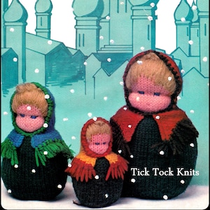 Op de afbeelding: Drie gebreide poppen met geborduurde gezichten en kleurrijke sjaals. De poppen staan voor een blauwe en witte achtergrond met een sneeuweffect. De tekst "Tick Tock Knits" is zichtbaar onderaan de afbeelding.